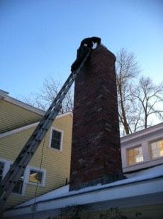 chimney worker on ladder working on chimney